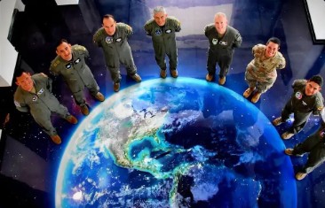 Grupo de oficiales alrededor de una imagen del planeta Tierra